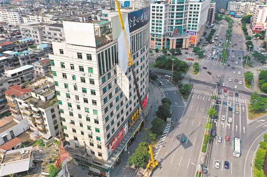 由于要拆除的廣告牌在樓頂，工作人員動用75米高的吊機進(jìn)行作業(yè)。