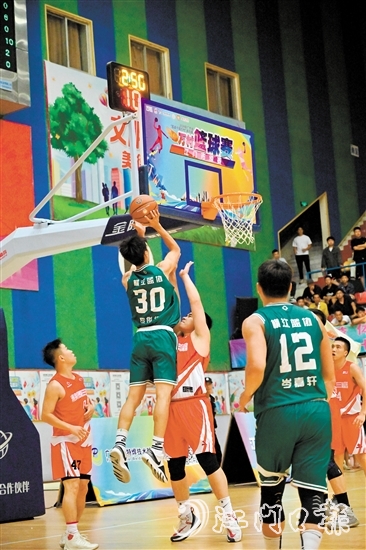萬村籃球賽江門市級賽決賽現(xiàn)場，橫江村隊(duì)隊(duì)員迎著防守跳投得分。
