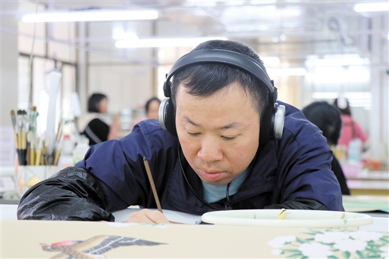 畫師戴著耳機(jī)，可以讓精神更專注。（受訪者供圖）