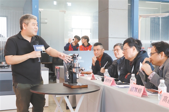 大賽評(píng)委與答辯企業(yè)代表交流產(chǎn)品設(shè)計(jì)理念。