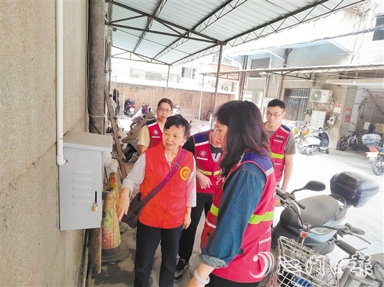 退休黨員干部鄧玉歡與網(wǎng)格員一起就充電樁選址開展調(diào)研。