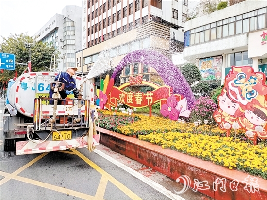 環(huán)衛(wèi)工人用心澆灌植物，擦亮城市容顏。