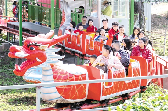 在位于江海區(qū)的江門長廊生態(tài)園，市民游客坐上小火車，享受闔家歡樂時光。