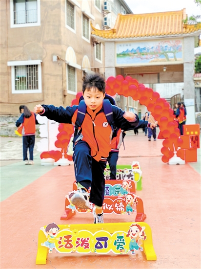 蓬江區(qū)荷塘鎮(zhèn)聯(lián)育小學(xué)學(xué)生跨過吉祥欄。