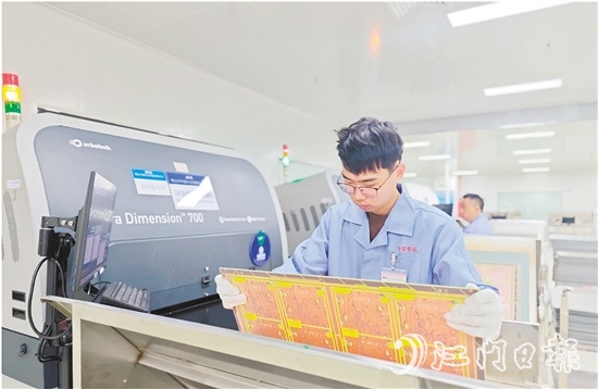 在鶴山中富生產(chǎn)車間，員工操作自動化設(shè)備趕制電路板。