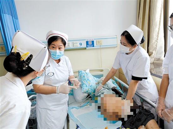 朱敏林（中）與同事對(duì)患者進(jìn)行護(hù)理服務(wù)。