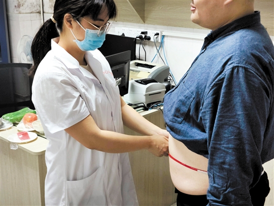 醫(yī)生為記者測(cè)量腰圍。
