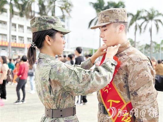 在歡送儀式現(xiàn)場(chǎng)，老兵姐姐為新兵弟弟整理軍裝。