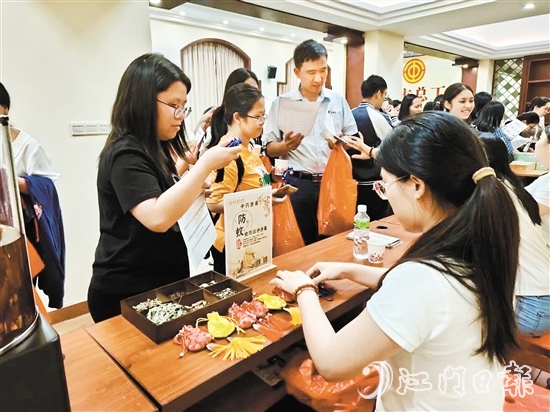 職工們與醫(yī)生探討中藥的成分和比例，制作防感驅(qū)蚊中藥香囊。