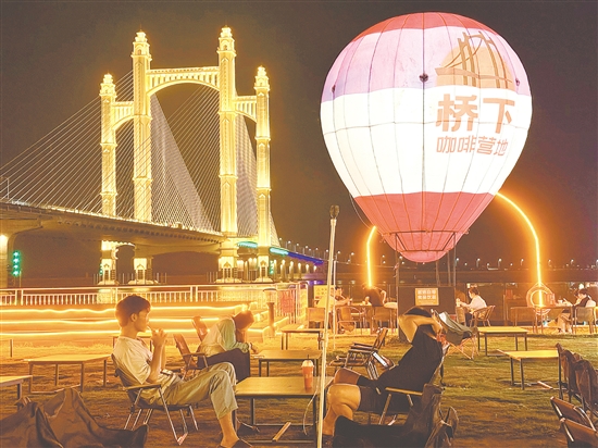 夜幕降臨，潭江兩岸燈火闌珊，市民、游客在“橋下咖啡營(yíng)地”品咖啡、賞夜景，享受愜意時(shí)光。