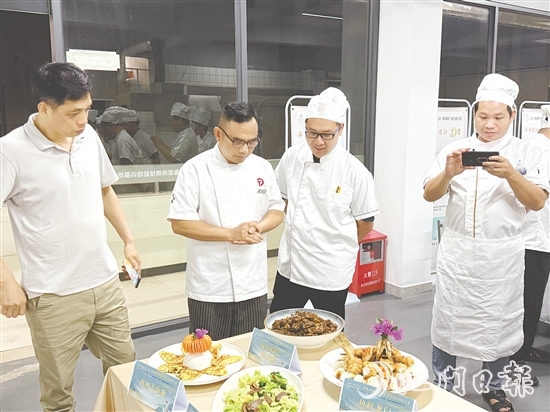 伍立更（左二）對(duì)學(xué)員們的自創(chuàng)菜式一一進(jìn)行點(diǎn)評(píng)和指導(dǎo)。