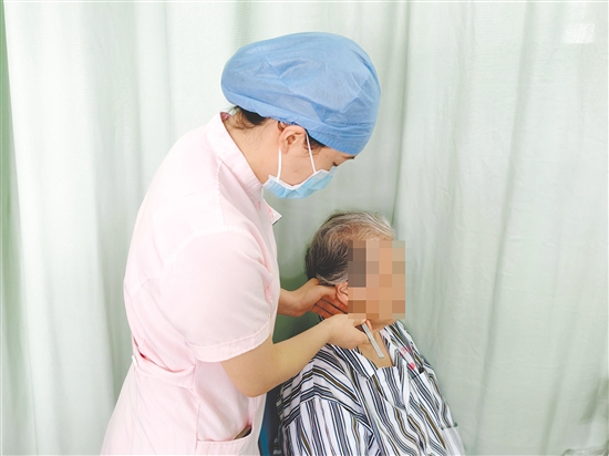 醫(yī)護人員為患者進行中醫(yī)外治療法。