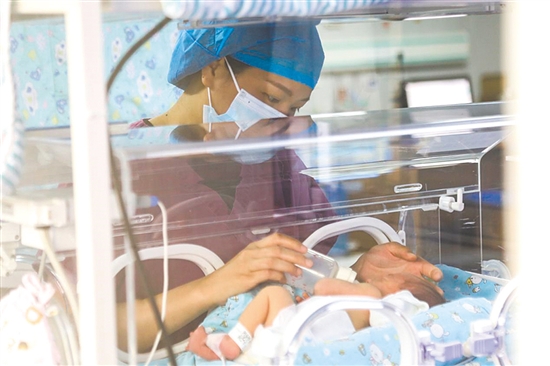 這是一雙小心翼翼的手。在江門市婦幼保健院新生兒科，護(hù)士李麗婷化身臨時“奶媽”，手持奶瓶給早產(chǎn)兒喂奶。她時而調(diào)整奶瓶角度，時而放緩速度，用耐心與愛心為小生命構(gòu)筑溫暖港灣，陪伴他們跨越成長路上最初的難關(guān)。