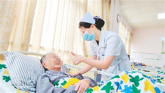 這是一雙傳遞溫度的手?！坝袝r去治愈，常常去幫助，總是去安慰”，江門市第三人民醫(yī)院內(nèi)科護(hù)士容海清站在床邊，將大拇指高高豎起，用輕柔的話語與溫暖的肢體語言，鼓勵臥床患者樹立康復(fù)的信心。