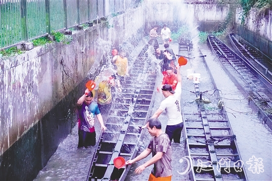 在水口鎮(zhèn)龍東村委會欖沖村，村民們合力將深埋河底的龍舟“喚醒”，為即將到來的端午龍舟賽事做準(zhǔn)備。