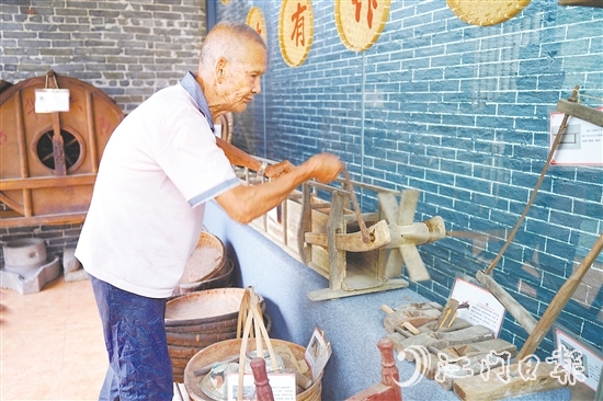 新華村打造農(nóng)耕文化展館，留住鄉(xiāng)村記憶。圖為村中老人向記者介紹農(nóng)具。