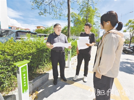 余中宏（左一）與同事一起查看“民生服務(wù)充電站”項目建設(shè)進度。