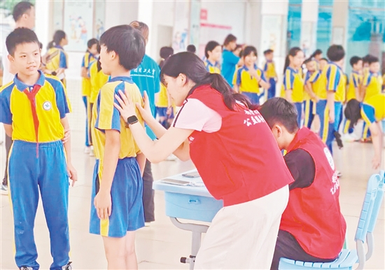 華南理工大學(xué)體育學(xué)院運動與健康科研團隊為學(xué)生進行專業(yè)的脊柱側(cè)彎篩查。