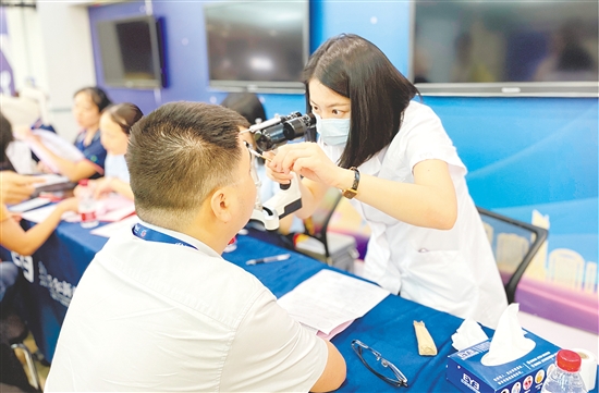 醫(yī)護(hù)人員為企業(yè)職工檢查眼睛。