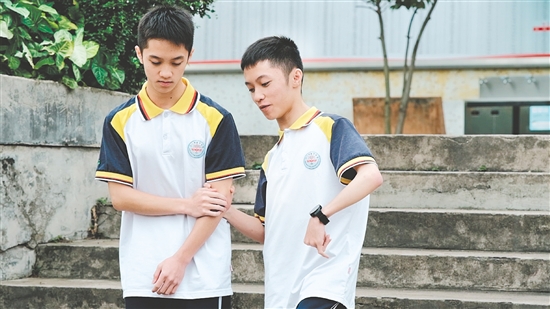 校園里，弟弟（左）和哥哥（右）相互扶持。