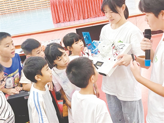 服務(wù)隊(duì)隊(duì)員向孩子們展示氫燃料電池演示儀。