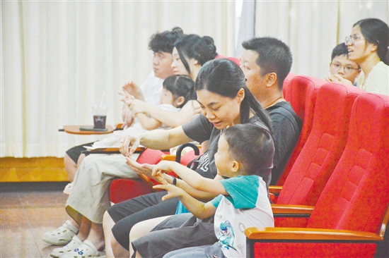 家長在聽講座時，根據(jù)醫(yī)生的講解在練習(xí)推拿。