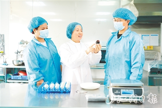 在培訓(xùn)室里，梁艷芬（中間白衣）和大家交流蛋品檢測(cè)方式。