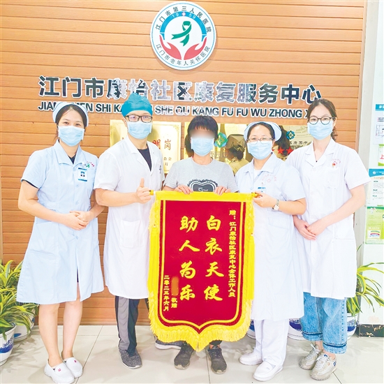 李明給康復中心醫(yī)護人員送上錦旗。