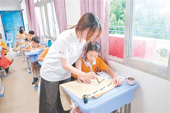 社會實踐隊隊員指導學生練習硬筆、軟筆書法。