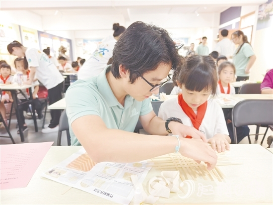 學生志愿者耐心教導孩子制作手工。