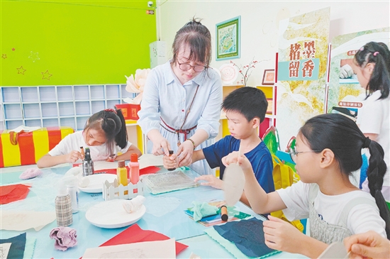 在導(dǎo)師的指導(dǎo)下，孩子們紛紛拿起紙張，在拓板上謹(jǐn)慎操作。