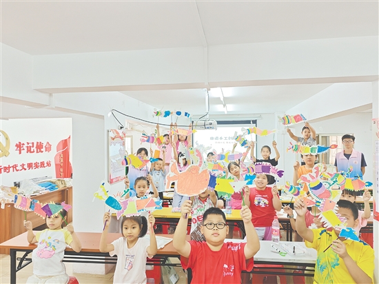 孩子們手持自制荷塘紗龍一起合照，課堂變民俗小舞臺(tái)。