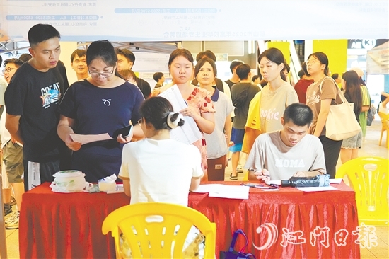 活動現(xiàn)場，求職者手持簡歷與企業(yè)招聘人員進行交流。