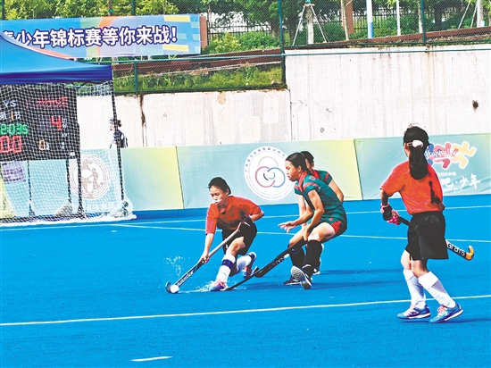 共和鎮(zhèn)中心小學女子曲棍球隊隊員（紅色隊服）在比賽中頑強拼搏。