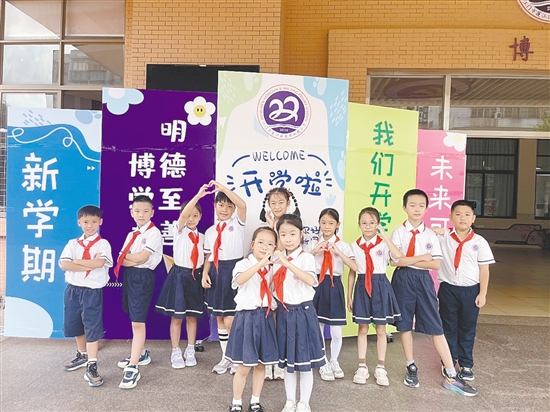 開(kāi)學(xué)首日，農(nóng)林雙朗小學(xué)的學(xué)生們?cè)趯W(xué)校精心準(zhǔn)備的背景板前留影。