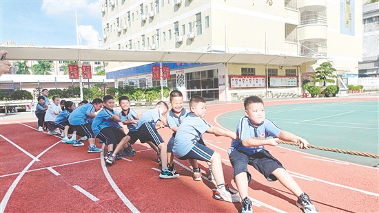 參賽隊員們緊握長繩，齊心協(xié)力，鼓足勁拼命往后拉。