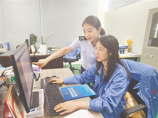 稅務(wù)工作人員輔導(dǎo)納稅人開展涉稅業(yè)務(wù)。