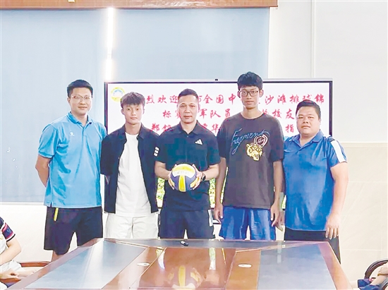 鄭銘毅（左二）與譚華鋒（右二）將親筆簽名的排球贈予母校。