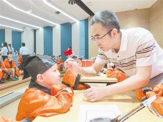 在朱砂啟智環(huán)節(jié)，教師用毛筆在新生的額頭點(diǎn)上紅痣。