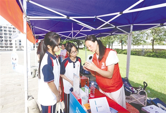 工作人員向新入學(xué)學(xué)生介紹醫(yī)保線上辦事流程。