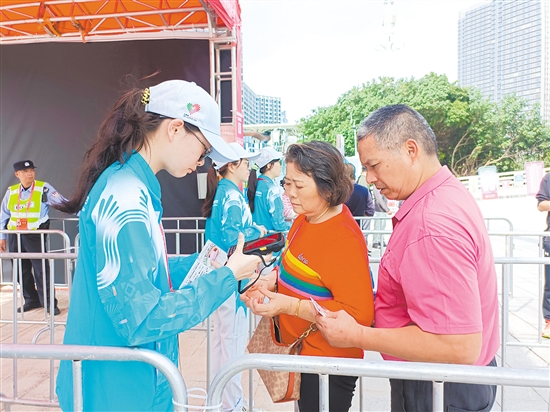 志愿者在場館外為觀眾檢票。
