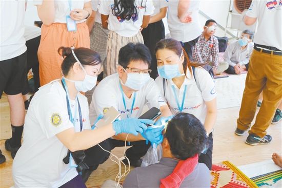 鐘景賢參加“柬埔寨光明之行”，為當(dāng)?shù)匮奂不颊哌M行檢查。