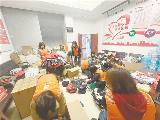 家長(zhǎng)義工們正在加班加點(diǎn)打包衣物。