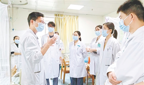 黃任鋒（左前一）對(duì)學(xué)生講解藥方使用。