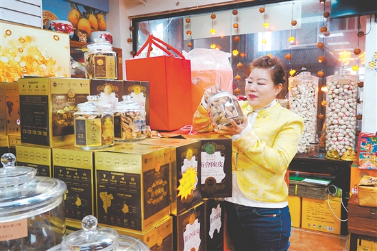 在新會傳誠廣陳皮商鋪，負(fù)責(zé)人任霞在查看新會陳皮禮盒情況。