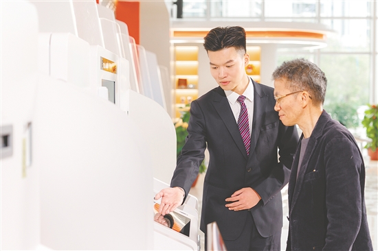 江門農(nóng)商銀行工作人員在為客戶講解社?？ǚ?wù)。