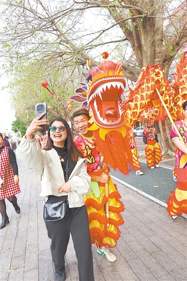 春節(jié)期間，江南路金龍巡游，吸引市民駐足合影。