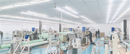 江門鴻榮紡織研究院有限公司的生產(chǎn)車間內(nèi)，一臺臺先進設備全速運轉，工作人員正有條不紊地操作設備。