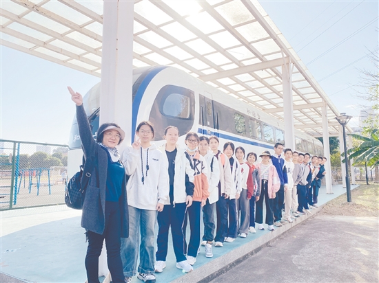 梁峻華（左一）帶領(lǐng)學(xué)生在五邑大學(xué)交通軌道實(shí)訓(xùn)基地研學(xué)。