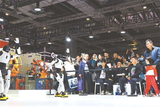 圖為當(dāng)日，參觀者在展會(huì)現(xiàn)場(chǎng)觀看人形機(jī)器人舞蹈表演。新華社發(fā)